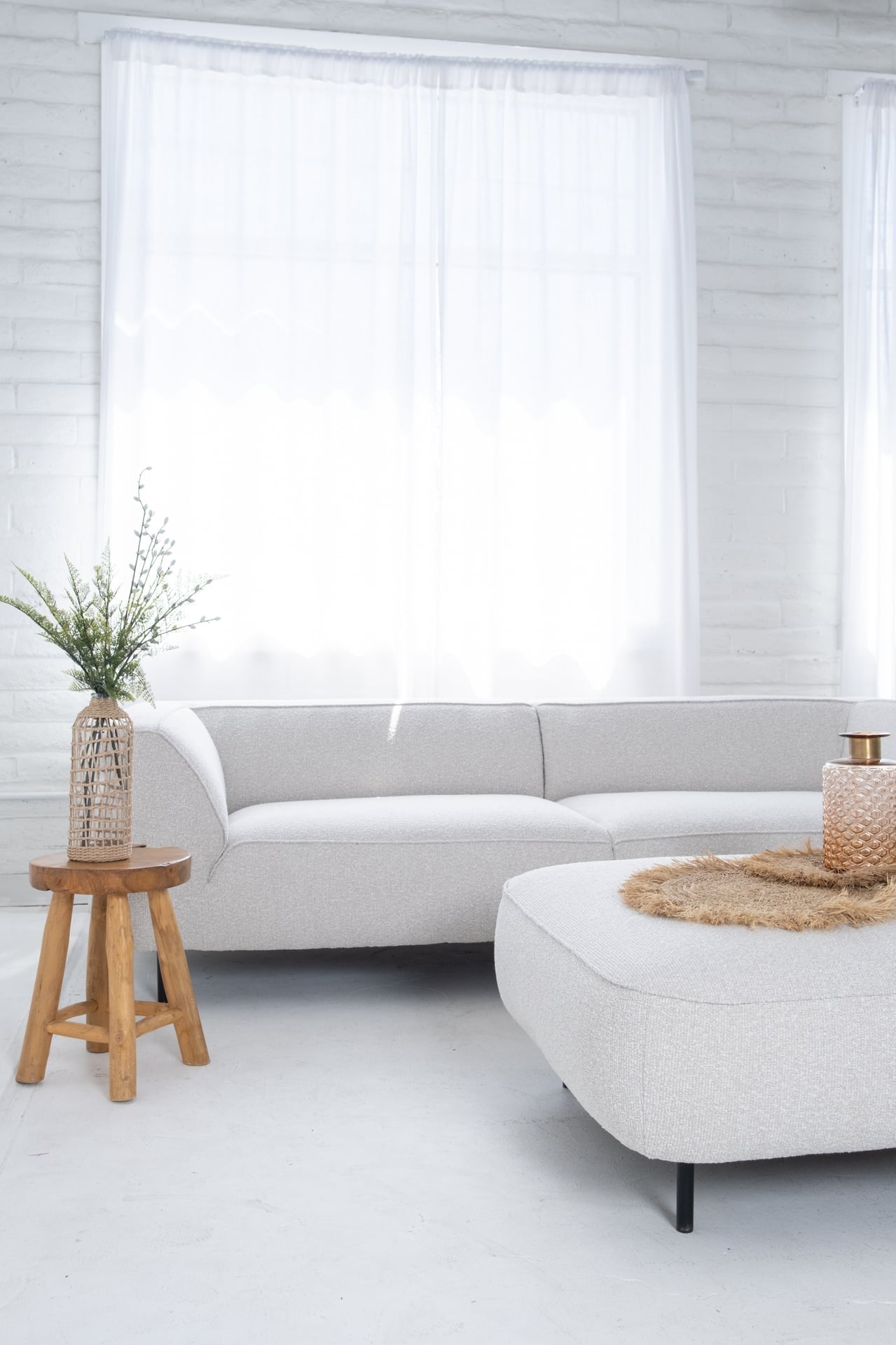 Modern living room with a gray sofa, wooden side table, and white walls.