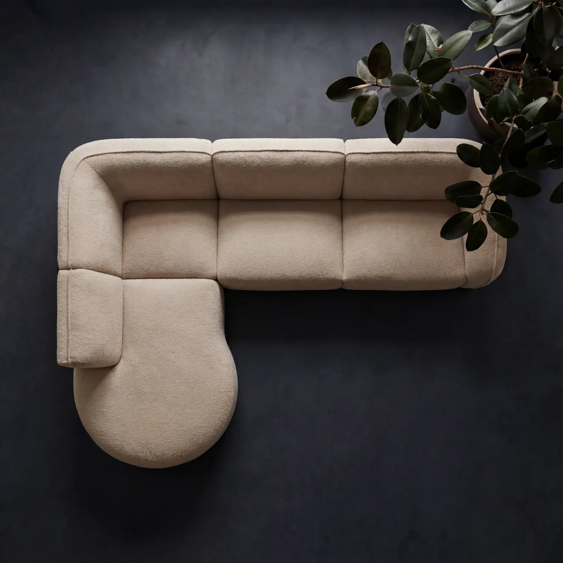 Loures Open-End Sectional — overhead architectural silhouette on charcoal with bold plant