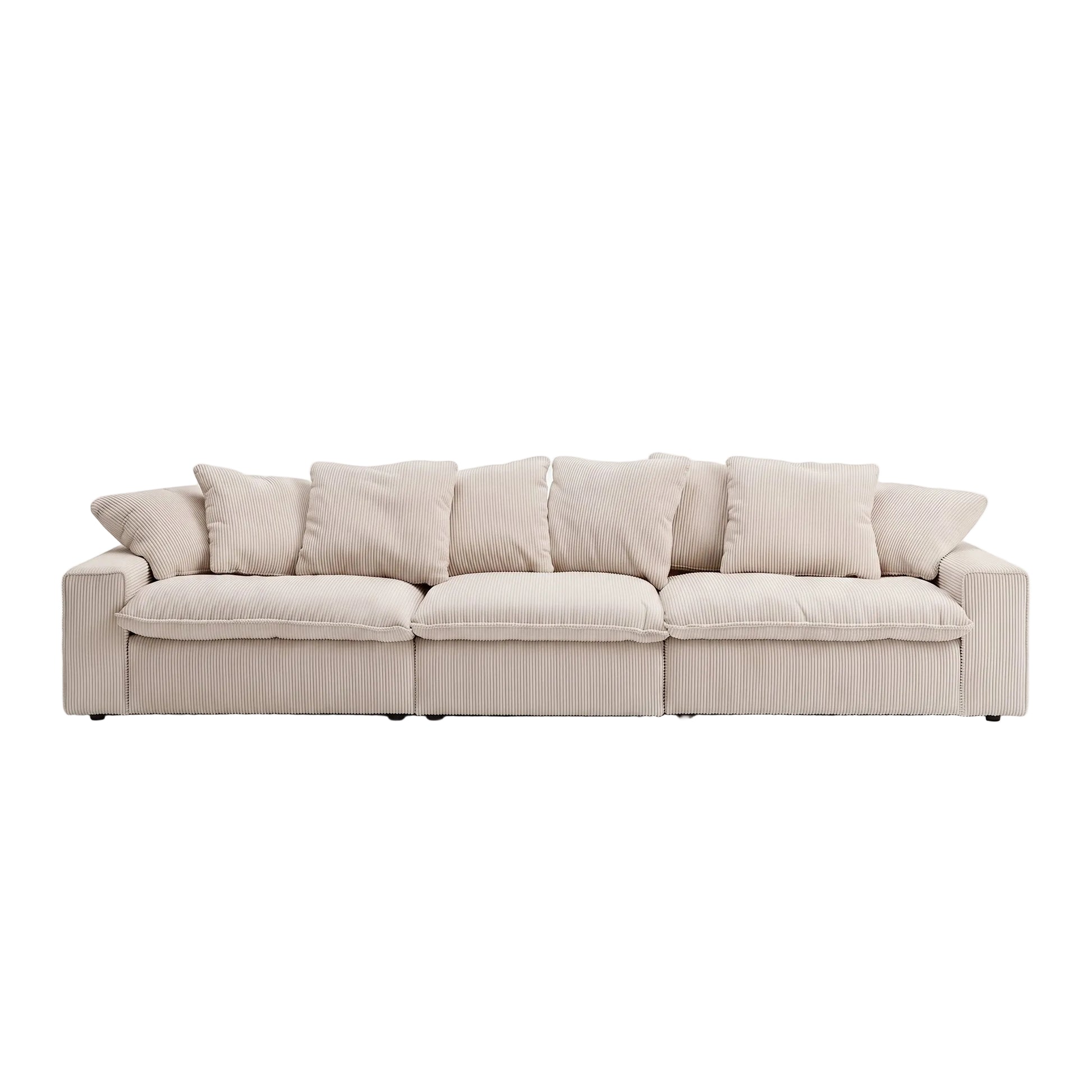 A modern three-seater sofa upholstered in a light beige ribbed fabric, featuring multiple square back cushions and matching throw pillows, set against a seamless white studio background.