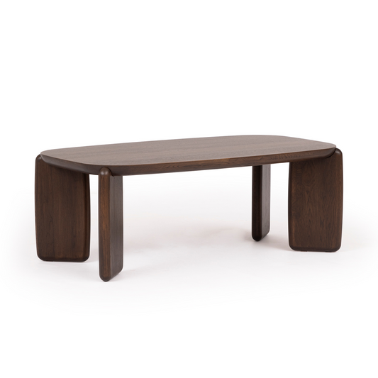 A rectangular Tono coffee table made of solid oak with deep walnut finish, featuring unique rounded edges and bold, architectural legs.